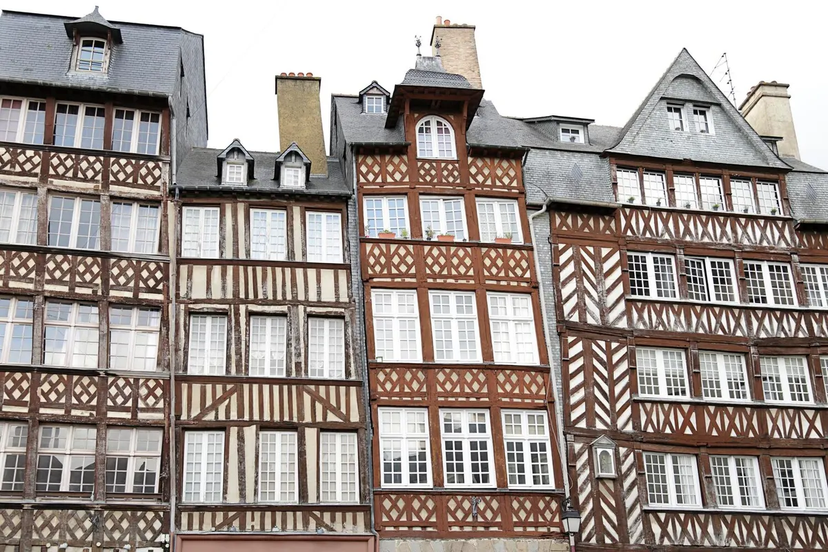 Façades de maisons à pans de bois aux fenêtres à petits carreaux et toits d'ardoise dans le centre ancien de Rennes